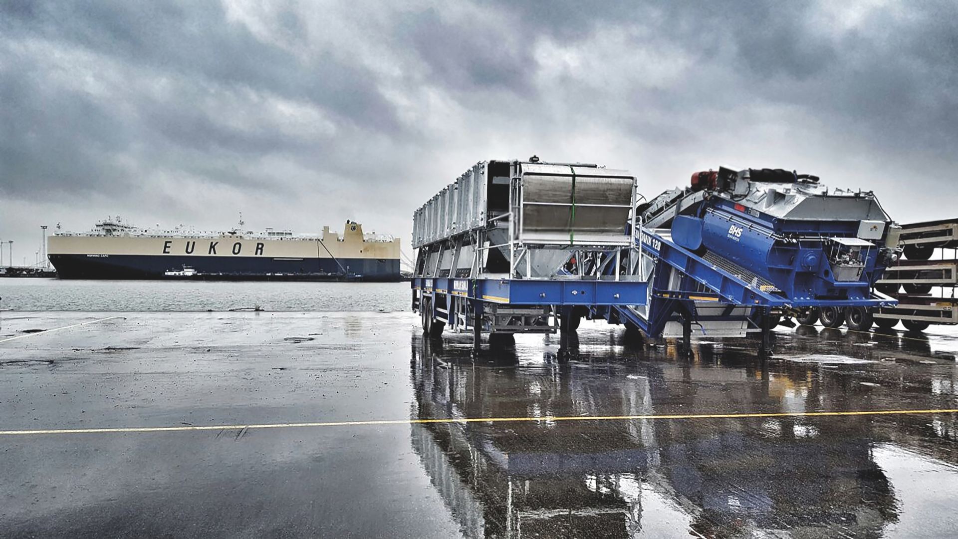 A NISBAU mobile mixing plant on the quay beside a car-carrier ship, ready for shipping