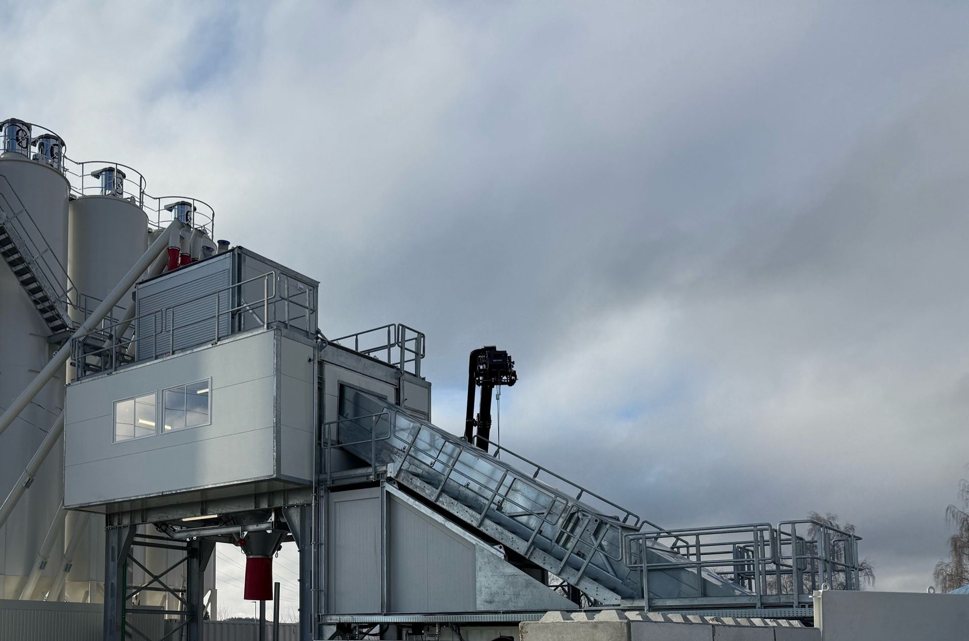 A NISBAU Prime mobile plant with silo bank and inclined conveyor on site in Germany