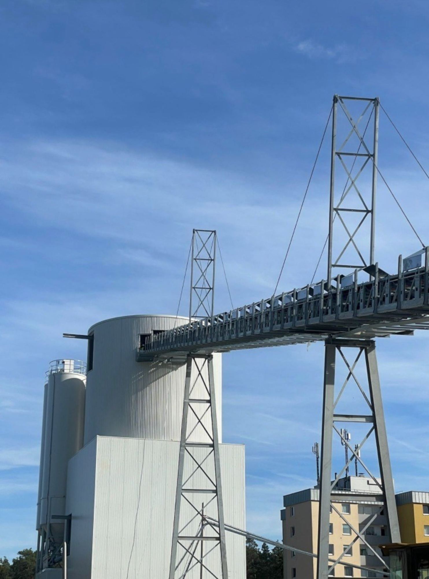 Upward view of the twin cement silo cluster of a NISBAU PRO Tower plant