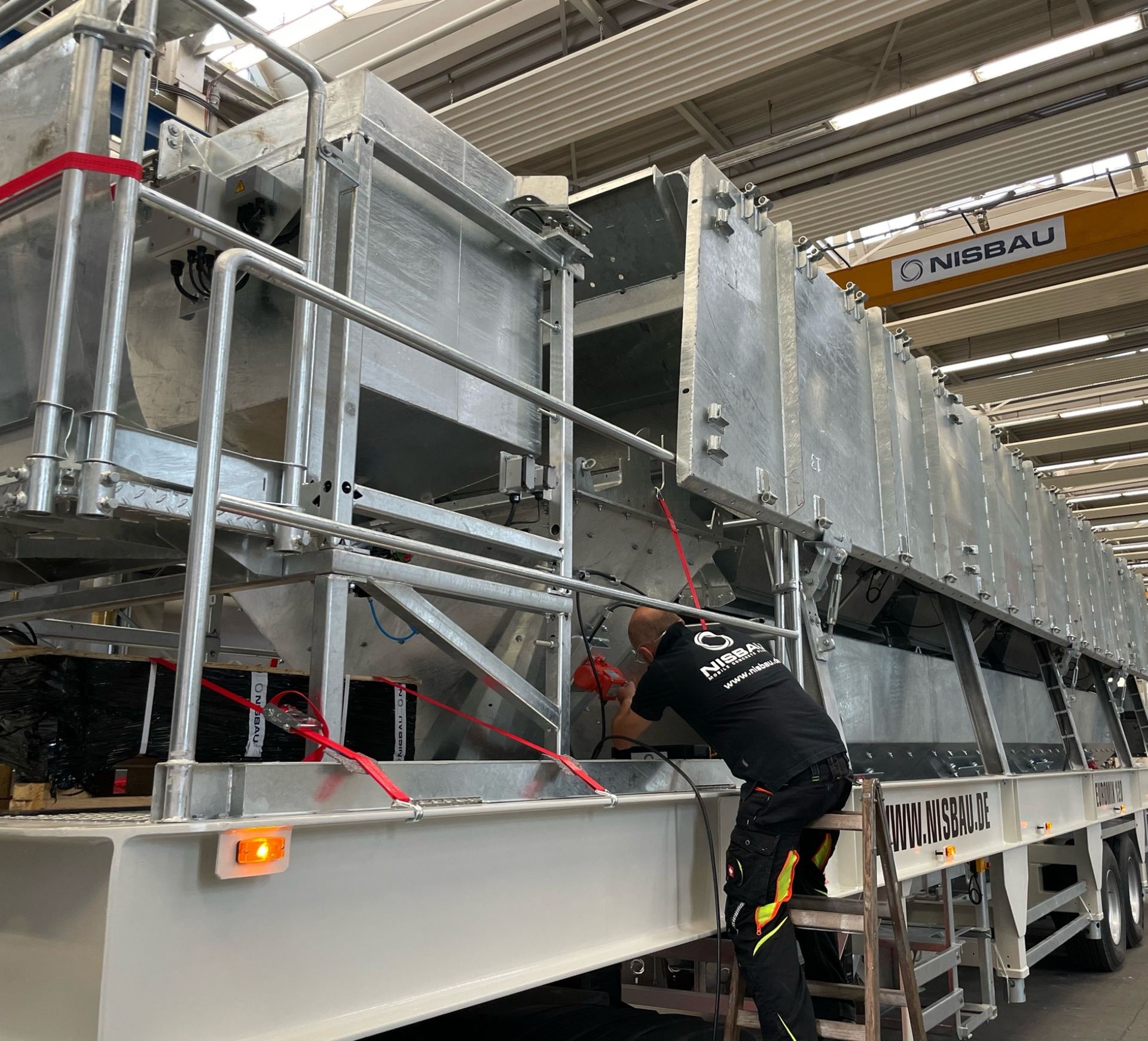A NISBAU EUROMIX plant secured for transport under the NISBAU crane in the works hall