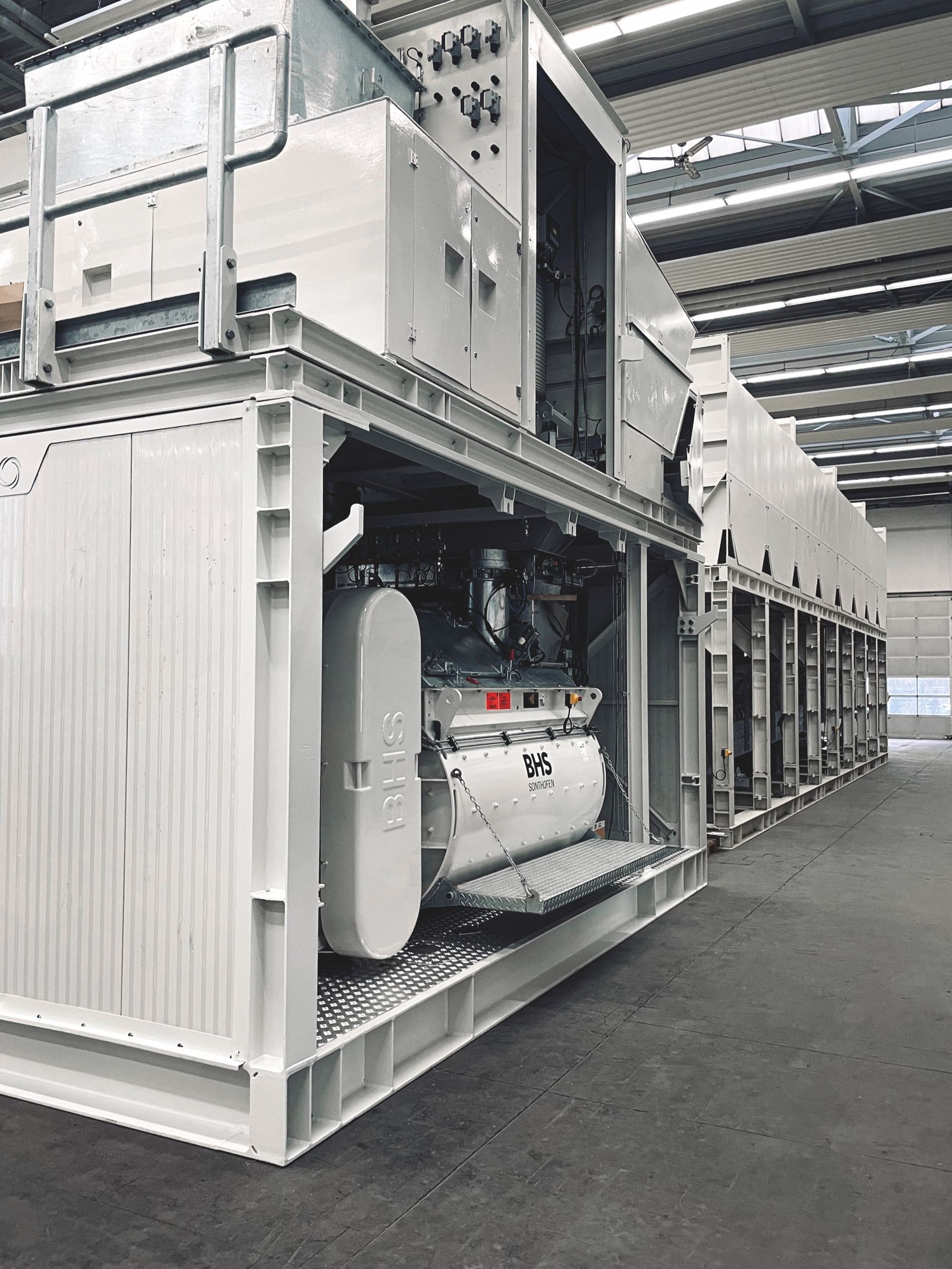 Finished NISBAU mixing plants standing complete in the works hall in Germany, ready for shipment
